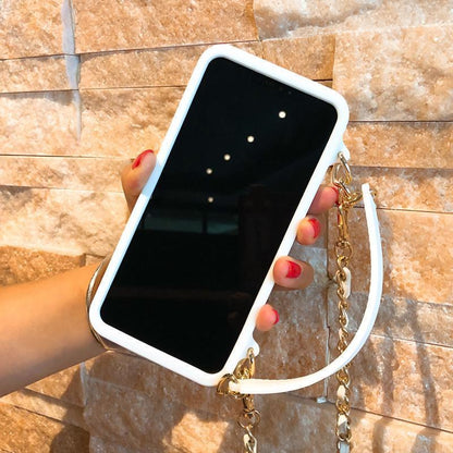 Schicke Handtasche mit Kettenriemen und Handyhülle